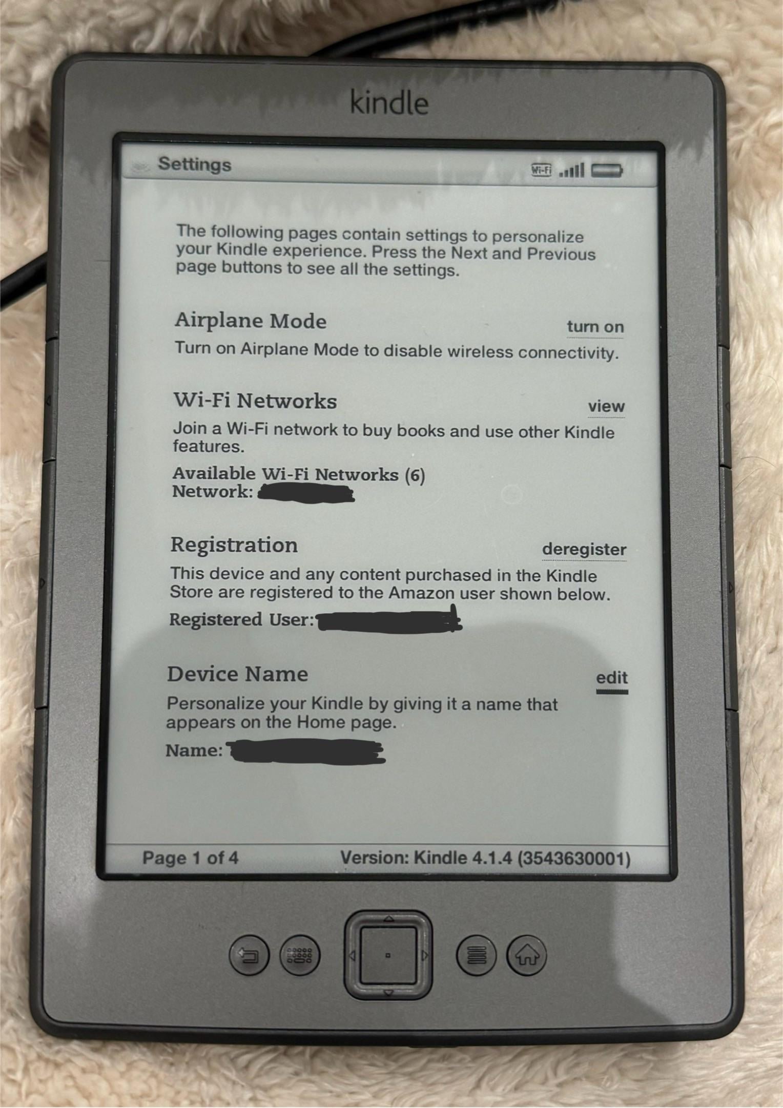 Close up of a 4th gen Kindle displaying a weak wireless signal icon.