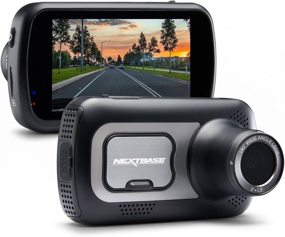 A laptop screen showing a firmware update progress bar near a dash cam.