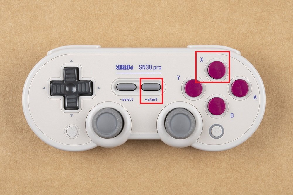 An 8BitDo SN30 Pro controller connected to a laptop for a firmware update.