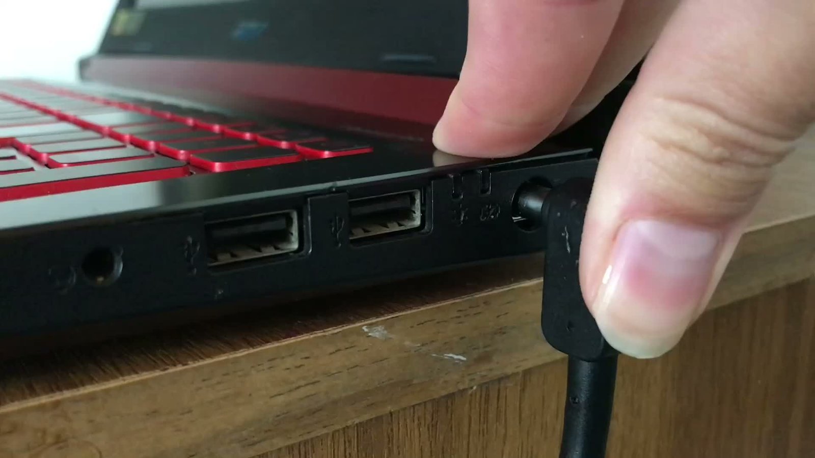 A person unplugging a laptop charging cable to troubleshoot a power connection.