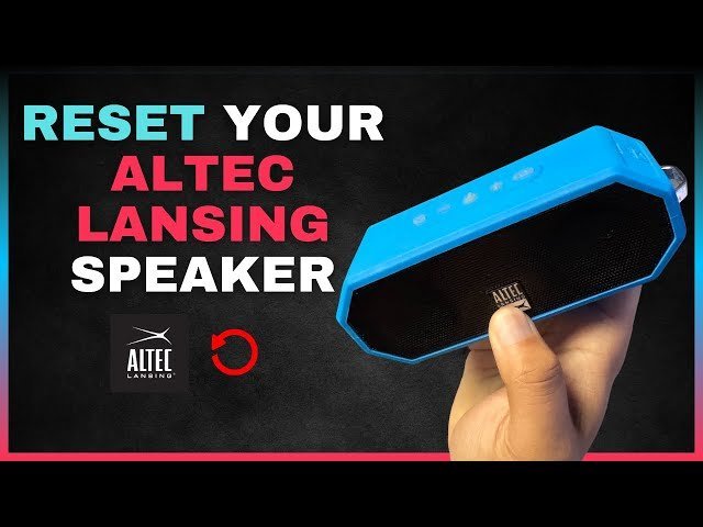 Cleaning debris out of a portable speaker charging port with a small tool.