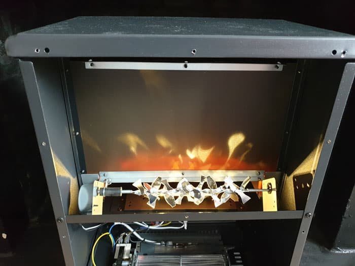 The internal mechanical components and wiring of an electric fireplace unit.