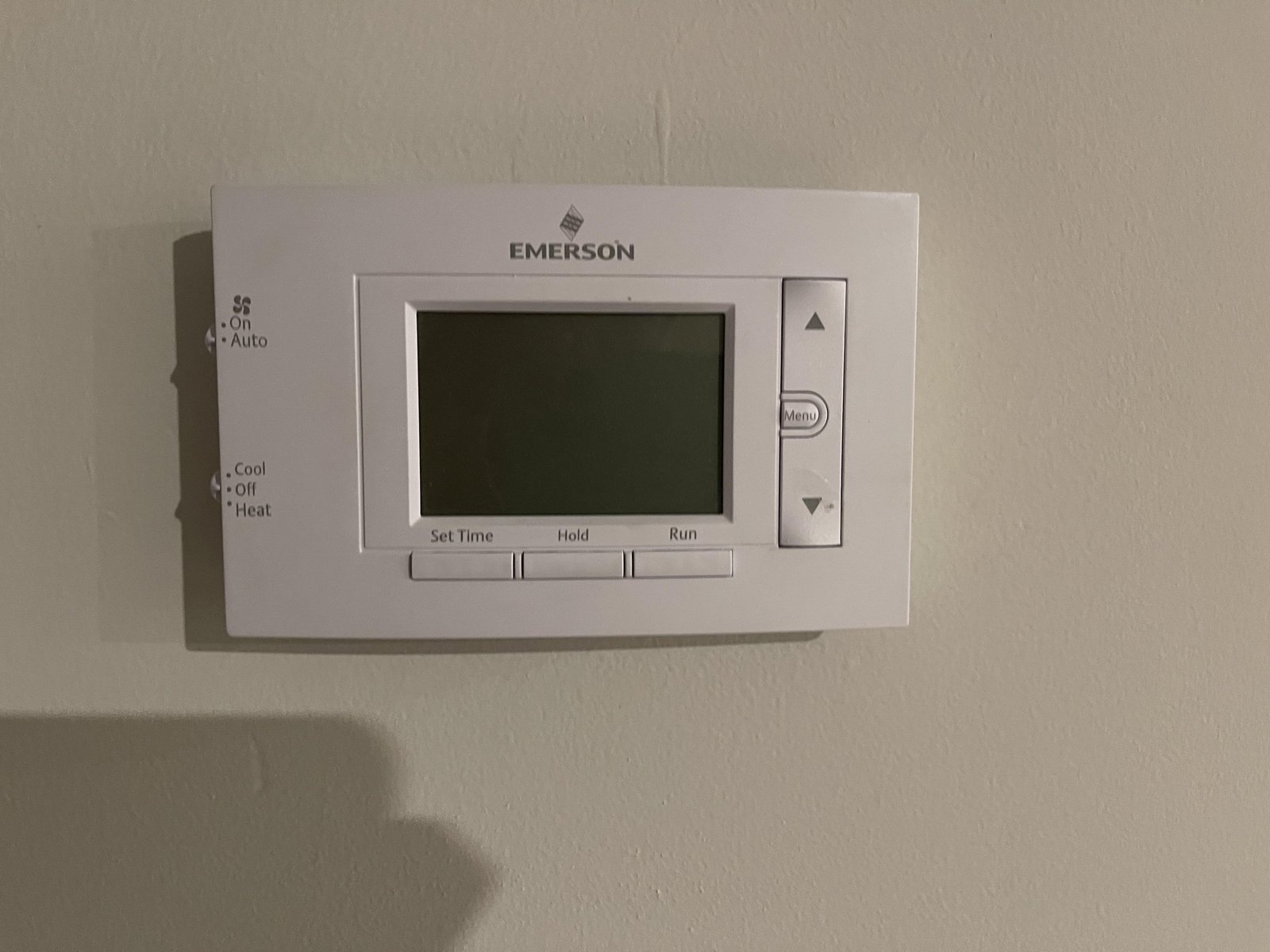 Replacing old batteries in an Emerson thermostat to fix a blank screen.
