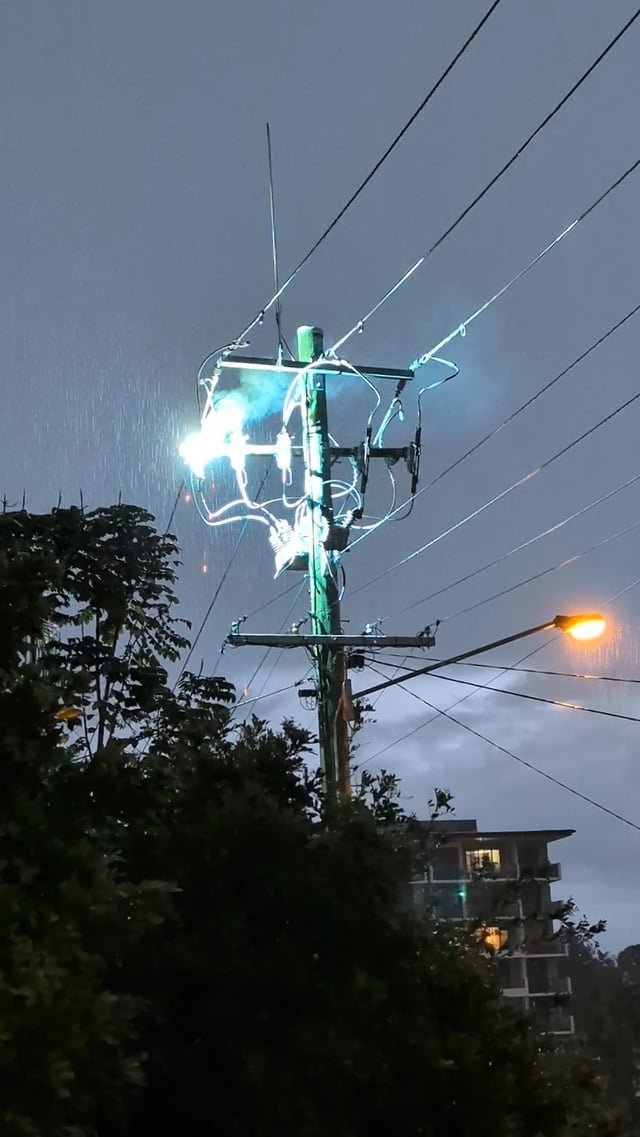 An entire row of street lights remains unlit on a dark suburban street.