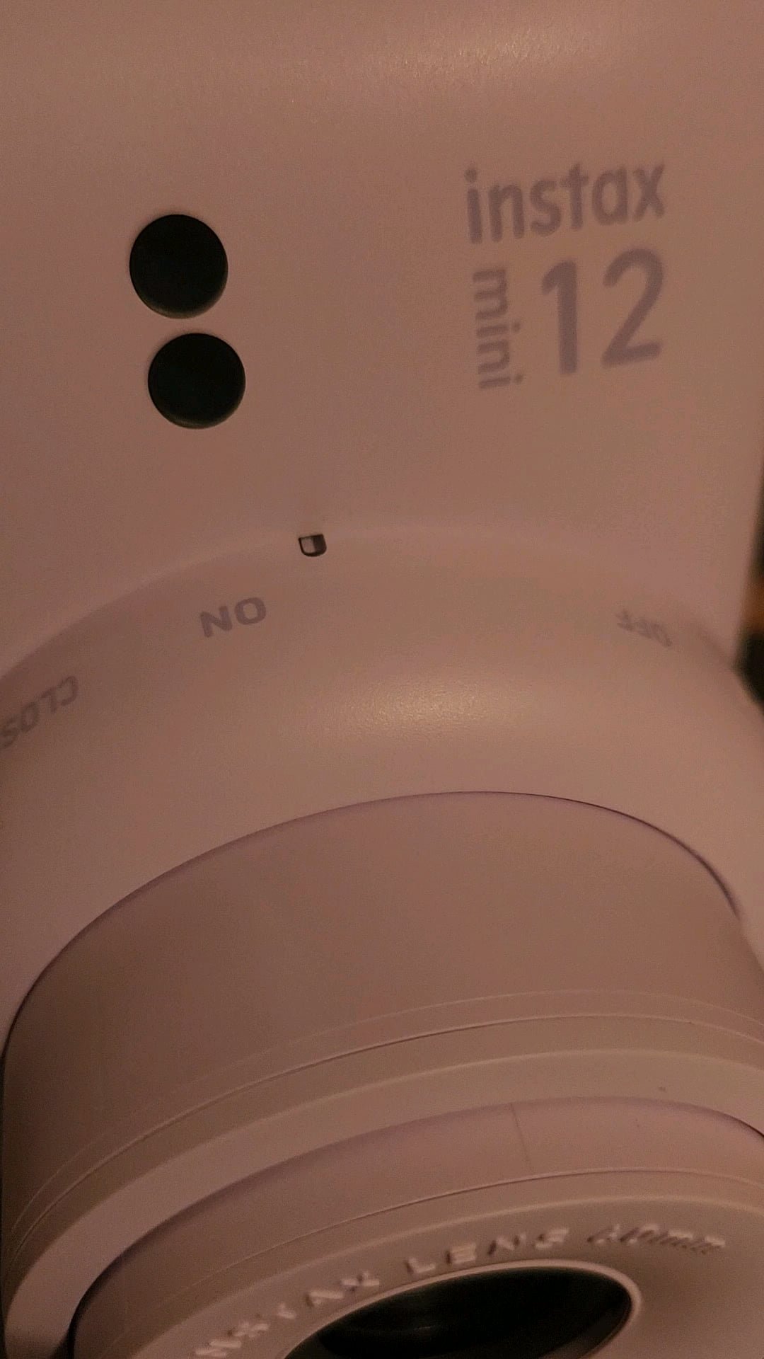 Close up view of the blinking status LED light on an Instax camera.