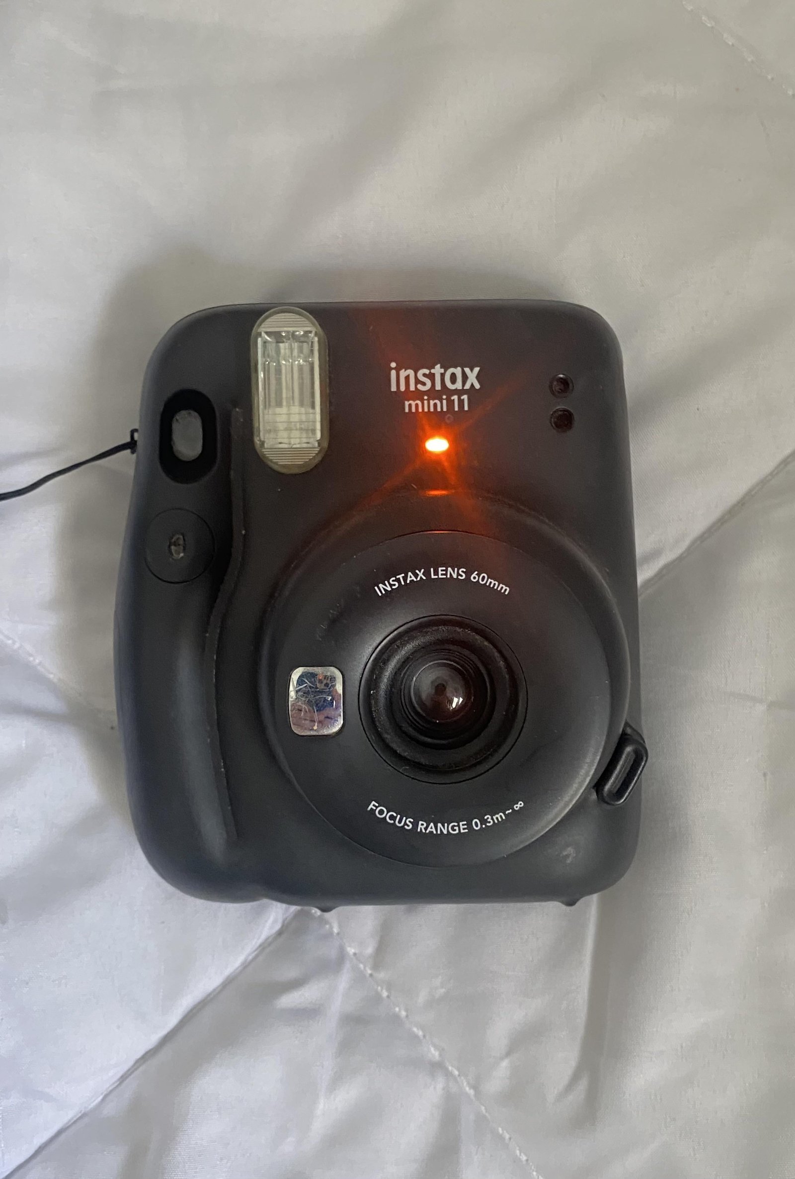 Close up of an orange indicator light blinking on an instant camera.