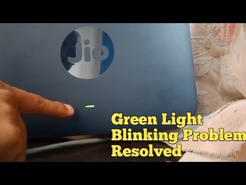A close-up of a Jio Fiber router with a blinking green status light.