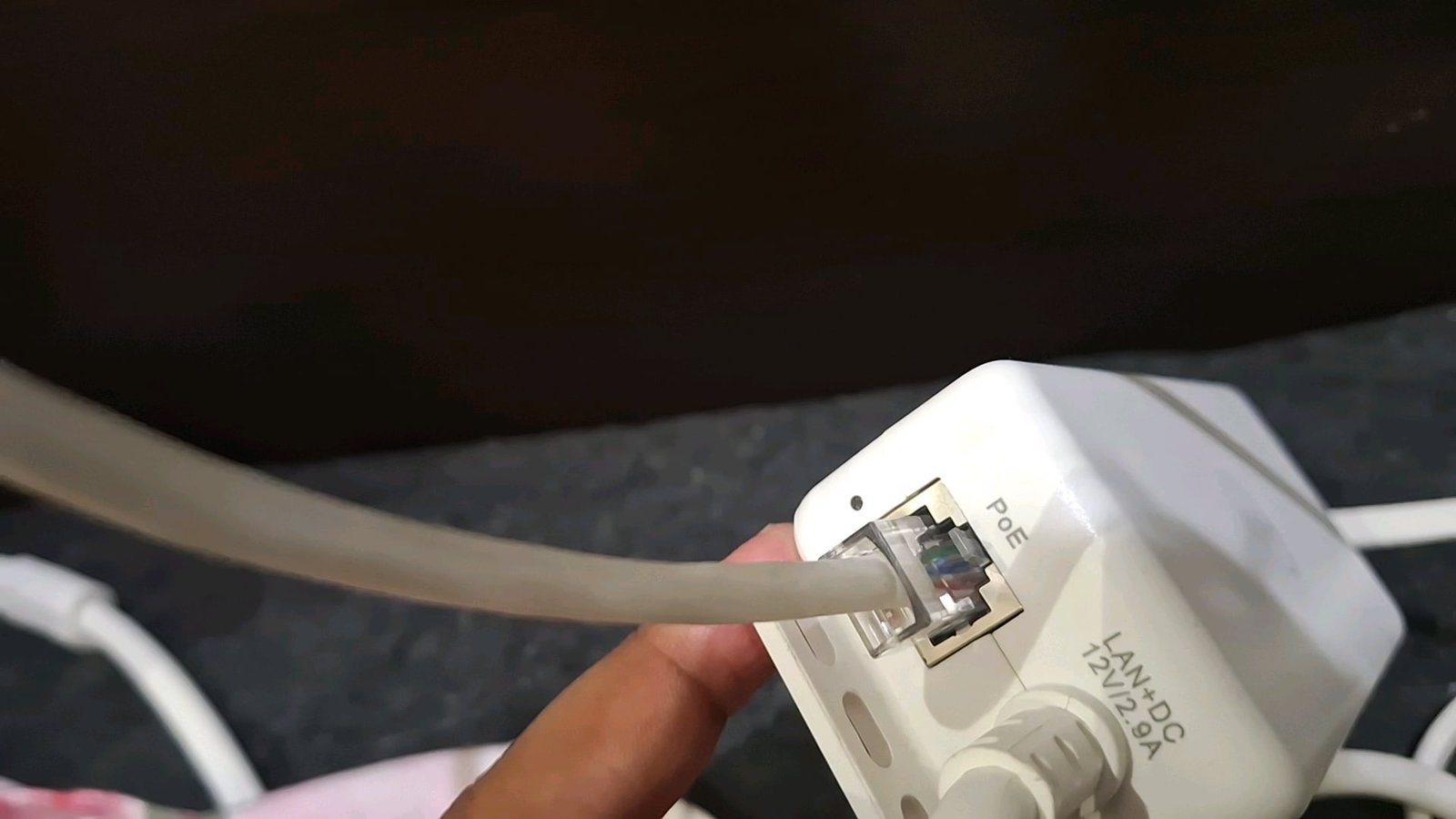 Close up of a fiber optic cable connector being inspected for a physical signal disruption.