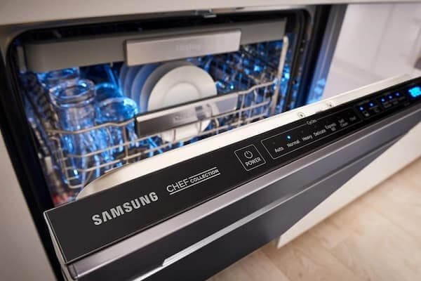 A person inspecting the internal filter of a dishwasher to troubleshoot blinking lights.