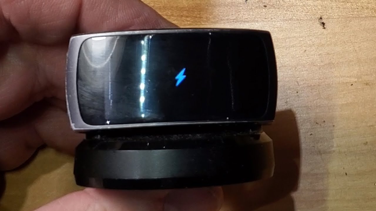 A microfiber cloth wiping dust from the back of a smartwatch sensor.