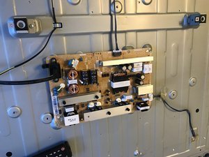 Unplugging a power cable from a wall outlet to reset a television.