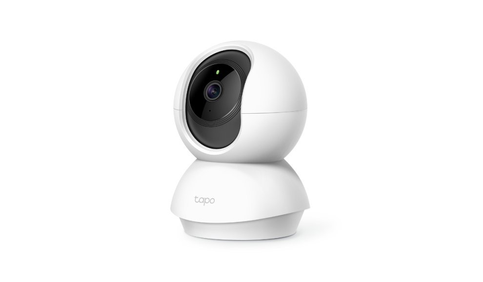 A close-up of a home security camera with a blinking red status light.