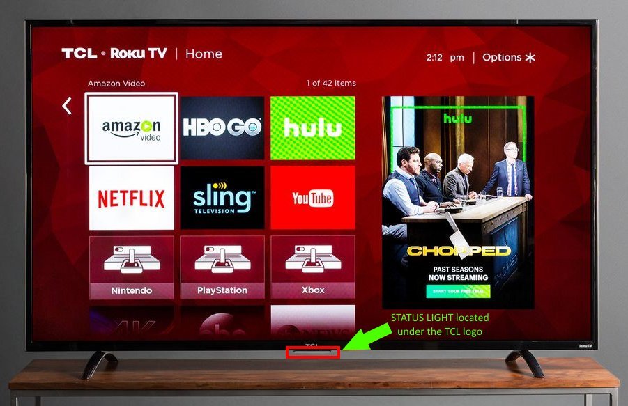 Hands unplugging a power cable from a wall outlet to reset a TV.